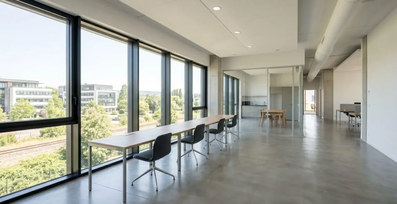 Bureau moderne français vide et lumineux avec grandes fenêtres, espace de travail contemporain épuré et architecture intérieure sobre